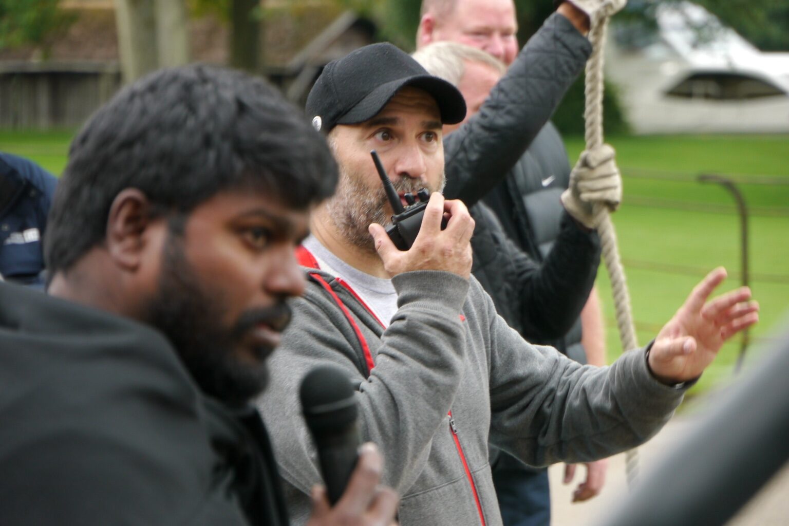 Peter Pedrero coordinating a wire stunt by radio as the rope team prepares the pull