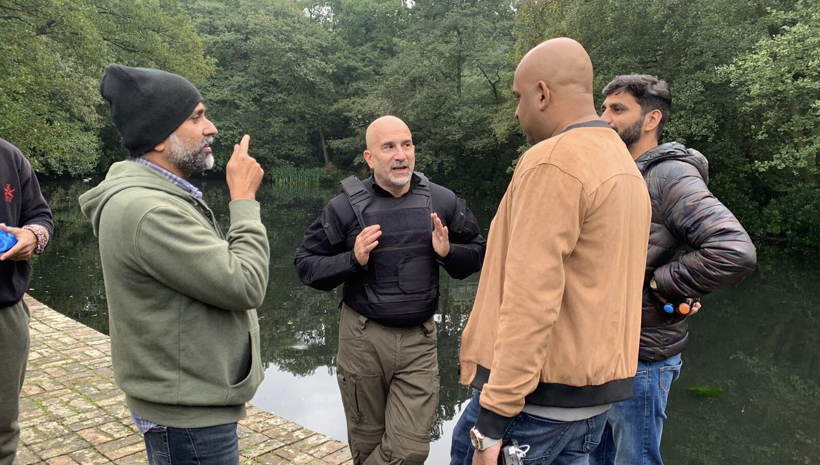 Peter Pedrero briefing the action team beside the lake with the director of photography
