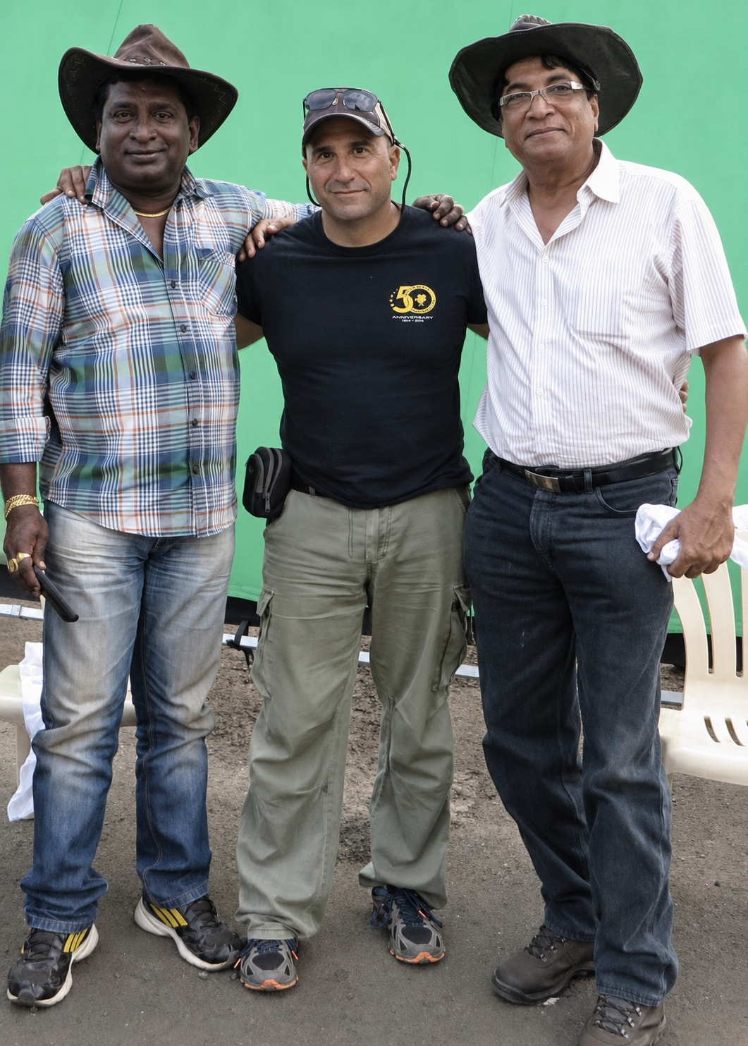 Peter with colleagues beside a green screen