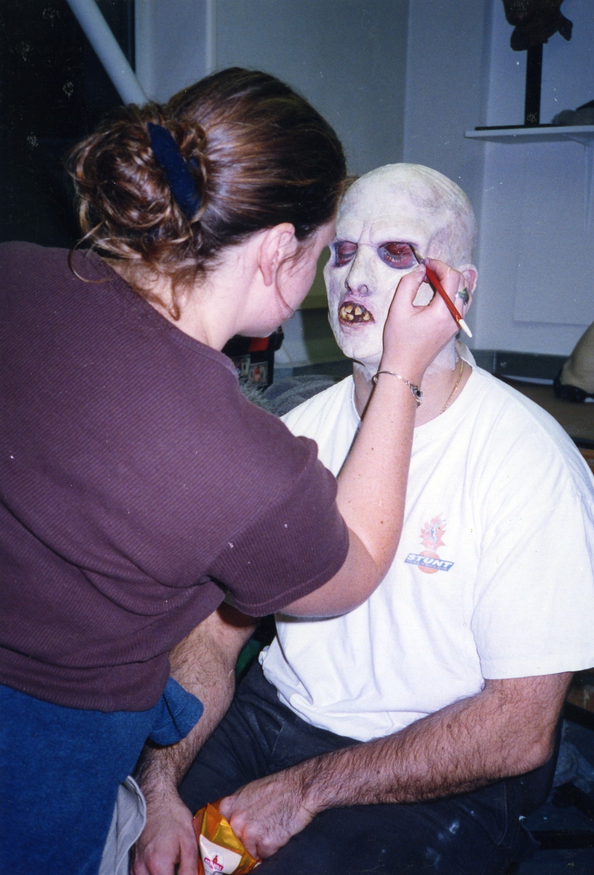 A makeup artist applying full-head creature prosthetics to Peter Pedrero — Devlin White — Zombie walker